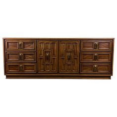 a large wooden dresser with many drawers and doors on it's front side, against a white background