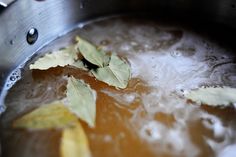 leaves are floating in the boiling pot of water