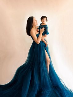 a woman in a blue dress holding a baby