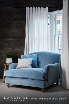 a blue couch sitting in front of a window