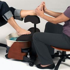 two people sitting in chairs with their feet on the chair