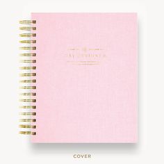 a pink notebook with gold writing on the cover