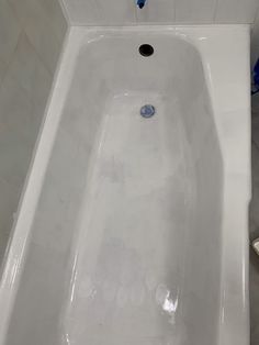 a white bath tub sitting inside of a bathroom next to a shower head and toilet