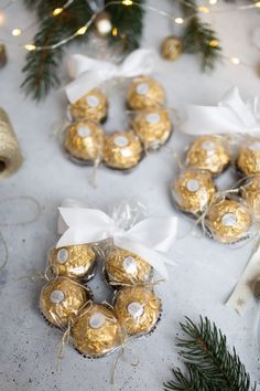 some chocolates are wrapped in gold foil and tied with white ribbon on the table