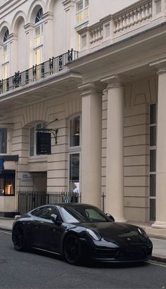 a black sports car parked in front of a building