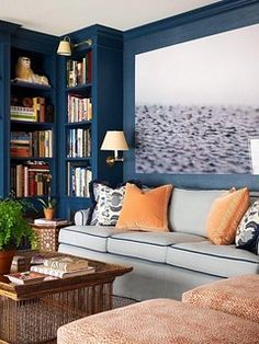 a living room filled with furniture and bookshelves covered in lots of different colored pillows