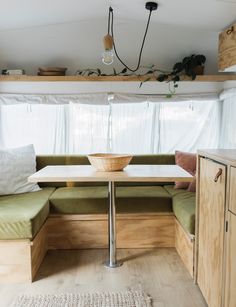 a kitchen area with a table, bench and window