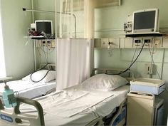 an empty hospital room with two beds and monitors