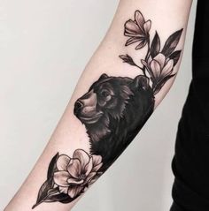 a bear and flowers tattoo on the arm