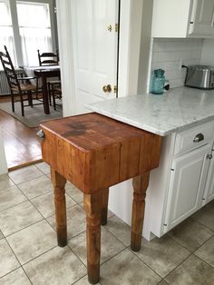 a wooden table sitting in the middle of a kitchen