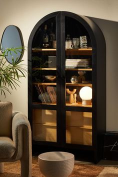 a living room with an arch shaped bookcase next to a chair and mirror on the wall