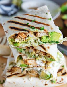 three burritos stacked on top of each other with avocado and chicken