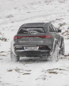 a mercedes suv driving through the snow