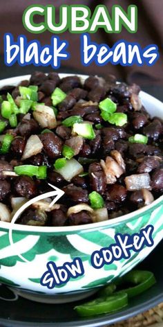 a close up of a bowl of food with black beans and green onions in it