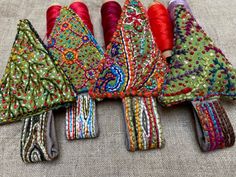 several different types of thread spools on a table cloth with some red, green, blue and yellow colors