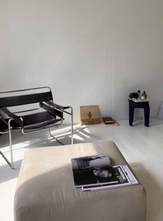 a living room filled with furniture and a book on top of a footstool