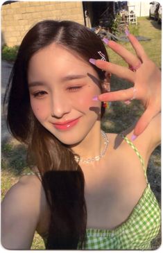 a girl with long hair and colorful nail polish holding her hands up to the camera