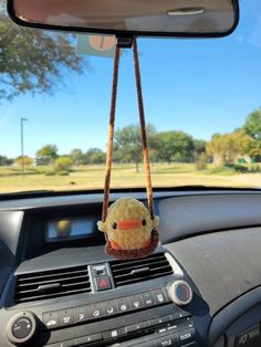 a car dashboard with a stuffed animal hanging from the dash board