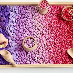 a wooden tray filled with lots of different colored rocks