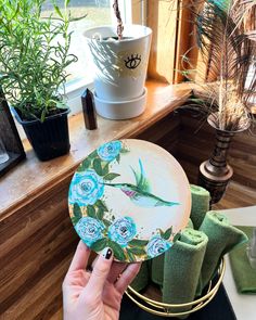 a person holding a plate with flowers painted on it