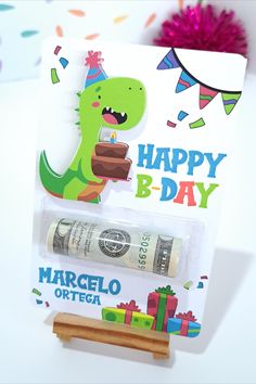 a birthday card with a dinosaur holding a piece of cake and money in front of it