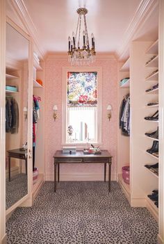 the closet is decorated in pink and black with a chandelier hanging from the ceiling