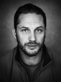 a black and white photo of a man looking at the camera with an intense look on his face