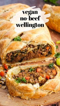 vegan no beef wellington is cut in half on a cutting board with other meats and vegetables