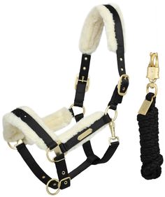 the bridle and harness are both black with white fur on it, while gold hardware