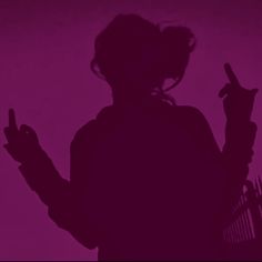 the silhouette of a woman holding a cell phone in her hand and pointing at it