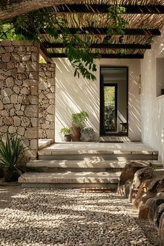 a house with stone steps leading up to the front door and covered in greenery