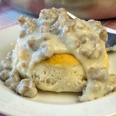 a white plate topped with an egg covered in gravy