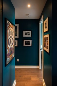 a hallway with blue walls and pictures on the wall