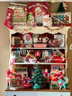 an old china cabinet is decorated with christmas decorations and santa clause on the top shelf