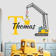 a wall decal with the name thomas on it and a construction crane in the background