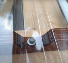 a close up view of a skateboard with wood and glass on it's side