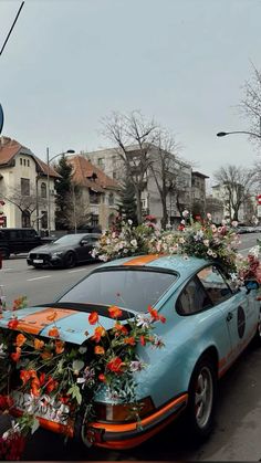 a car with flowers on the hood parked in front of a street sign