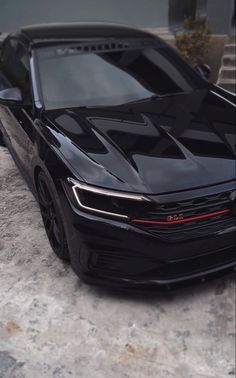 a black sports car parked in front of a building