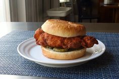 a chicken sandwich sitting on top of a white plate