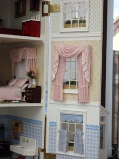 the doll house has pink curtains on it's windows