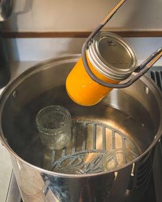 an orange juice is being poured into a saucepan