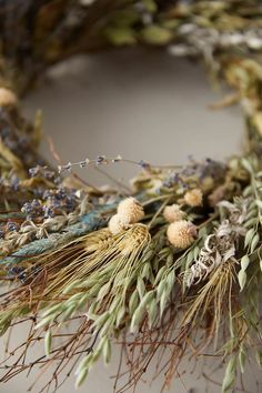 a wreath with dried flowers and leaves on it