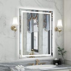 a bathroom with marble counter top and large mirror on the wall above it's sink