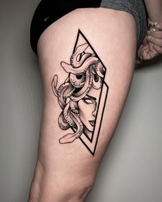 a woman's thigh with an octopus and triangle tattoo design on the side of her leg