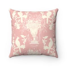 a pink and white pillow with birds, flowers and vases on it's side