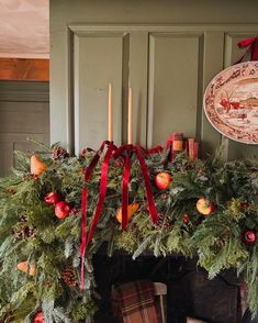 a fireplace decorated with christmas decorations and candles