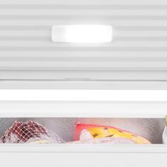 an open refrigerator door with the light on and food in it's bottom compartment