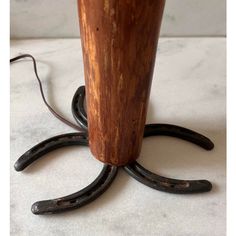 an old fashioned wooden lamp with two black iron rings on the bottom and one light brown