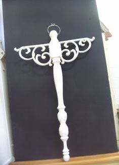 a white metal cross on top of a wooden table