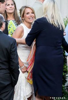 a woman in a white dress is shaking hands with a man